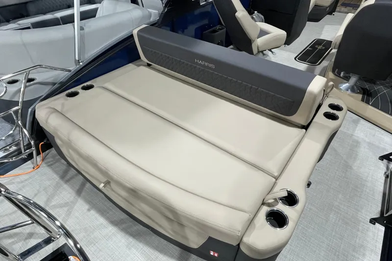 Slide: The Image of 2026 Harris SUNLINER 230 SLDH boat interior with beige seating and cup holders. - 11