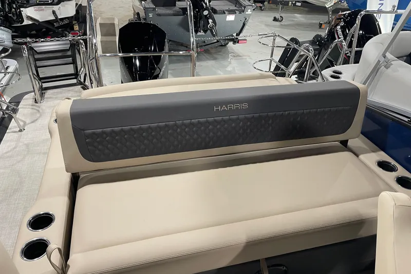 Slide: The Image of 2026 Harris SUNLINER 230 SLDH boat interior with beige seating and cup holders. - 12