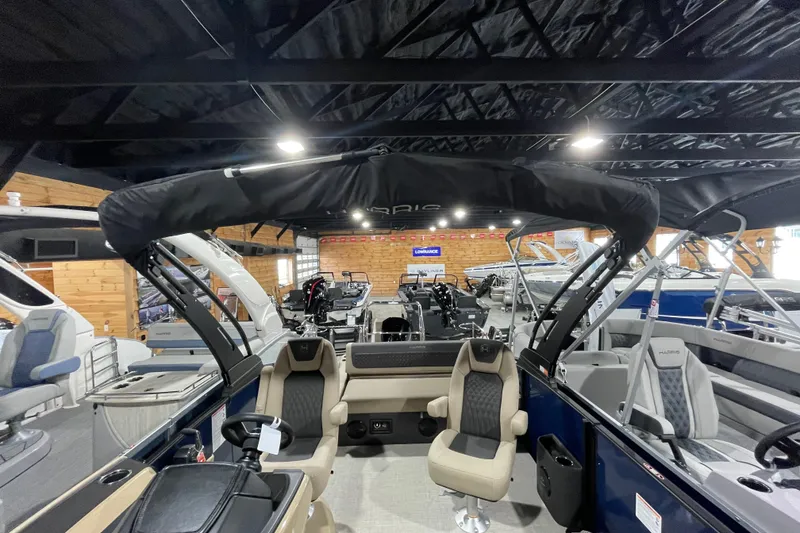 Slide: The Image of 2026 Harris SUNLINER 230 SLDH pontoon boat interior in showroom, featuring modern seating and controls. - 20