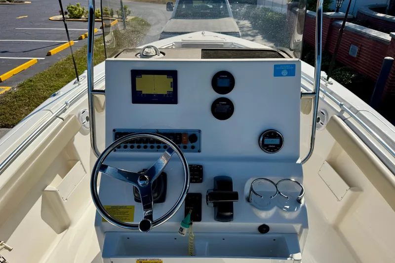 Slide: The Image of 2023 Key West 239 FS boat dashboard with steering wheel and navigation instruments. - 17