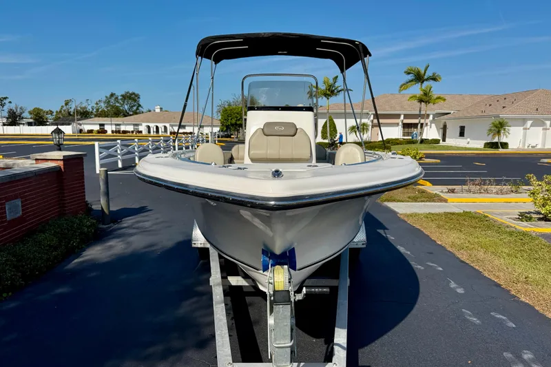Slide: The Image of 2023 Key West 239 FS boat on trailer, parked in sunny residential area. - 2