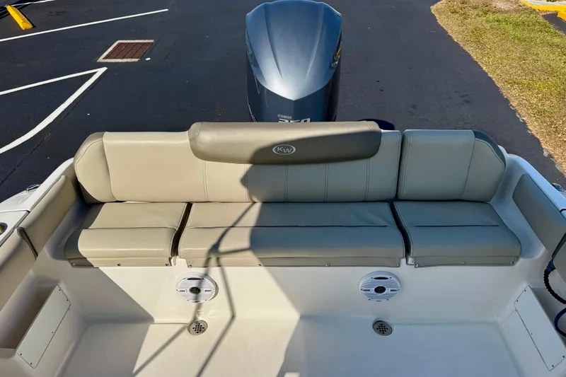 Slide: The Image of 2023 Key West 239 FS boat with cushioned seating and outboard motor. - 25