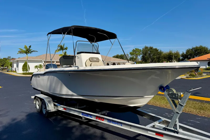 Slide: The Image of 2023 Key West 239 FS boat on trailer, parked outdoors under clear sky. - 3