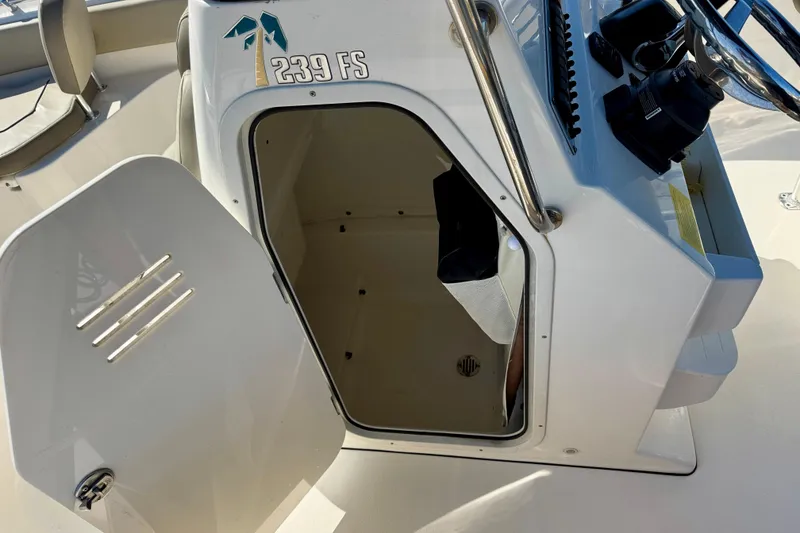 Slide: The Image of 2023 Key West 239 FS boat console with open storage compartment and steering wheel. - 33
