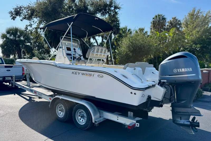 Slide: The Image of 2023 Key West 239 FS boat on trailer with Yamaha engine, parked outdoors. - 7