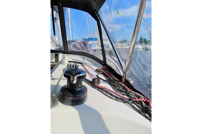 Slide: The Image of 2015 Salona 35 sailboat cockpit with winch and ropes, marina view. - 12