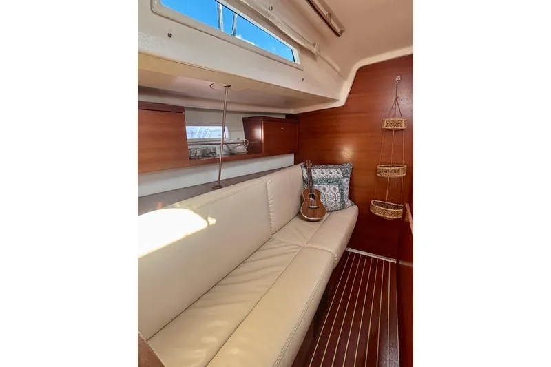 Slide: The Image of 2015 Salona 35 yacht interior with beige sofa, decorative pillows, and a ukulele. - 17
