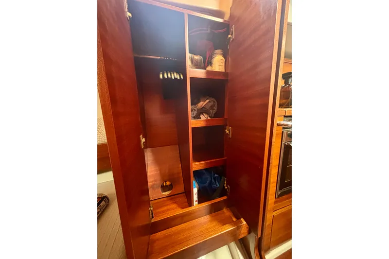 Slide: The Image of Wooden cabinet interior on a 2015 Salona 35 yacht, featuring shelves and storage items. - 41