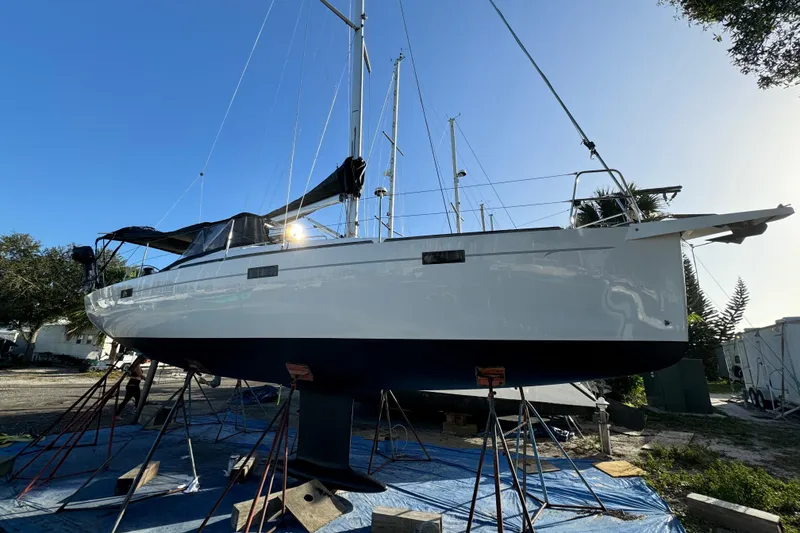 Slide: The Image of Sailboat Salona 35, 2015 model, on stands for maintenance under clear blue sky. - 44