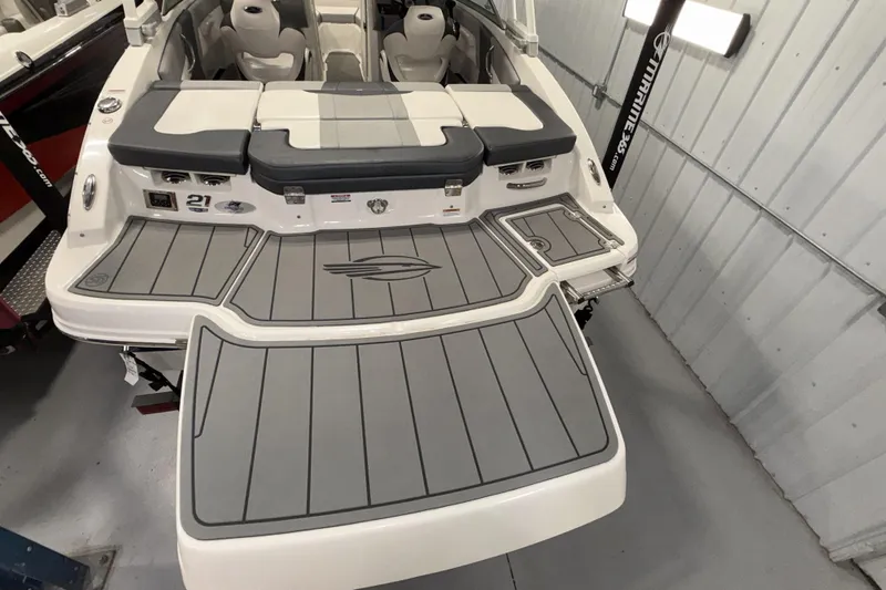 Slide: The Image of 2021 Chaparral 21 SSi boat with spacious seating and sleek design in a showroom. - 12