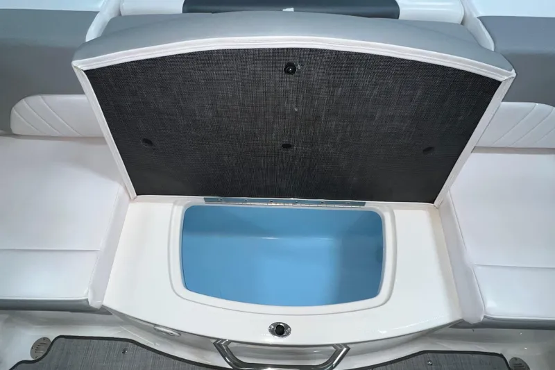 Slide: The Image of 2021 Chaparral 21 SSi boat with open storage compartment, featuring white and blue interior. - 15