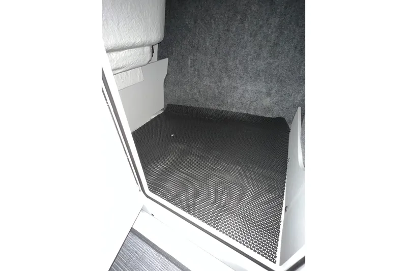 Slide: The Image of Interior storage compartment of 2021 Chaparral 21 SSi boat, featuring carpeted walls and non-slip flooring. - 17