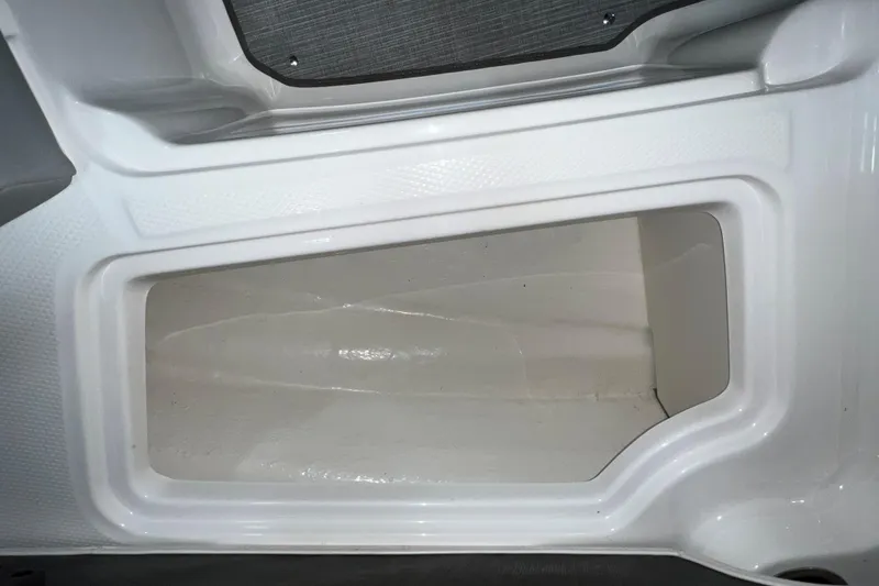 Slide: The Image of Storage compartment in 2021 Chaparral 21 SSi boat, featuring sleek white interior design. - 19