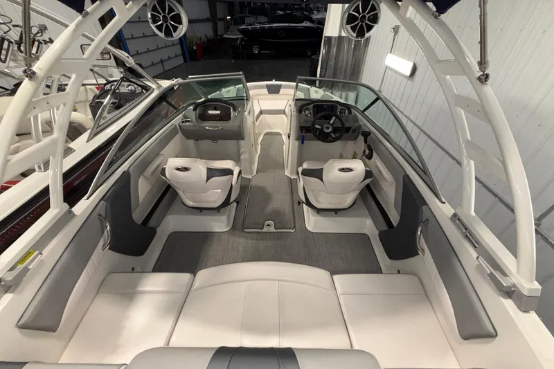 Slide: The Image of 2021 Chaparral 21 SSi boat interior with white seating and modern dashboard. - 7