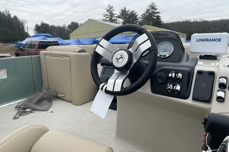 Slide: The Image of 2026 Harris Cruiser 230 boat interior with steering wheel and Lowrance navigation system. - 10