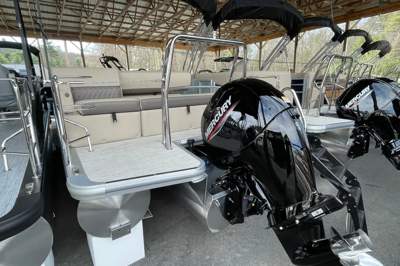 Slide: The Image of 2026 Harris Cruiser 230 pontoon boat with Mercury outboard engines under a wooden canopy. - 17