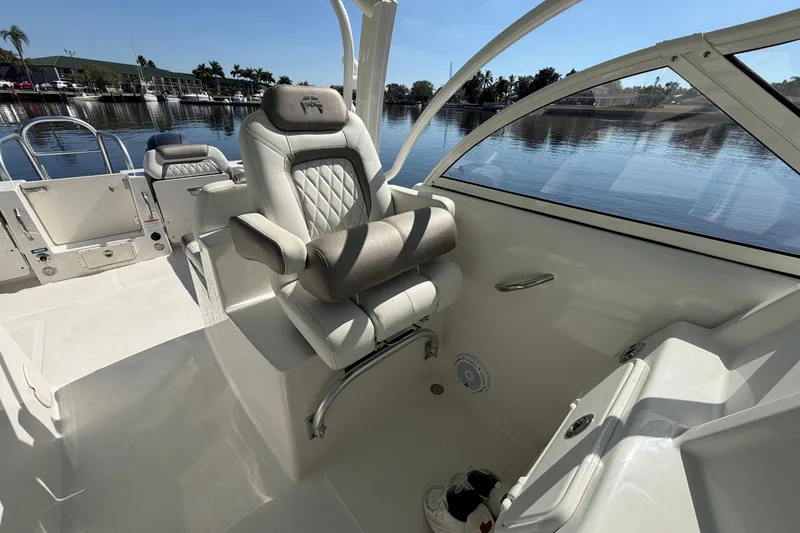 Slide: The Image of 2022 World Cat 255 DC boat interior with luxurious seating and waterfront view. - 11