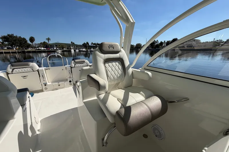 Slide: The Image of 2022 World Cat 255 DC boat interior with luxurious seating and scenic waterfront view. - 12