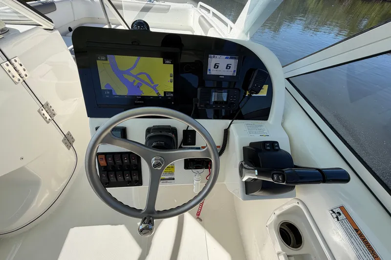 Slide: The Image of 2022 World Cat 255 DC helm with steering wheel, navigation display, and control panel. - 18