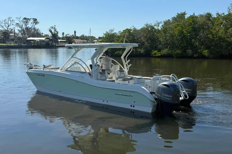 Slide: The Image of 2022 World Cat 255 DC boat with dual Yamaha engines on a calm river. - 5