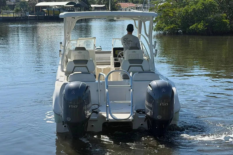 Slide: The Image of 2022 World Cat 255 DC boat with dual Yamaha engines on a calm waterway. - 6