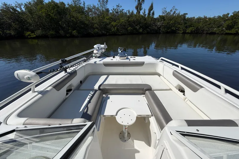 Slide: The Image of 2022 World Cat 255 DC boat interior with seating and table on calm water. - 7