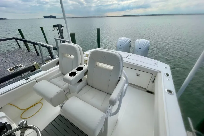 Slide: The Image of 2023 Regulator 28 Forward Seating boat with dual engines, docked by the water. - 14