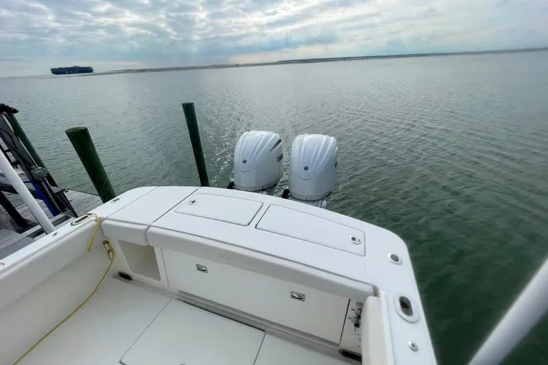 Slide: The Image of 2023 Regulator 28 Forward Seating boat with twin engines on calm water. - 15