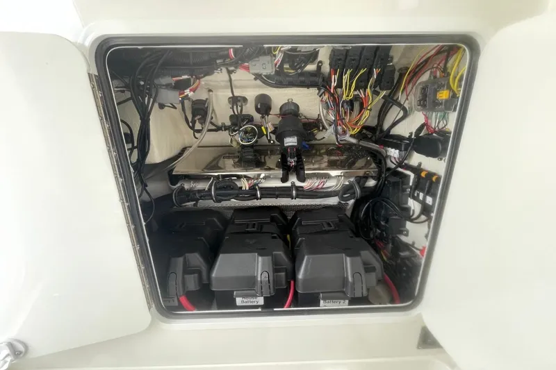Slide: The Image of Electrical compartment of 2023 Regulator 28 Forward Seating boat, showing wiring and batteries. - 28