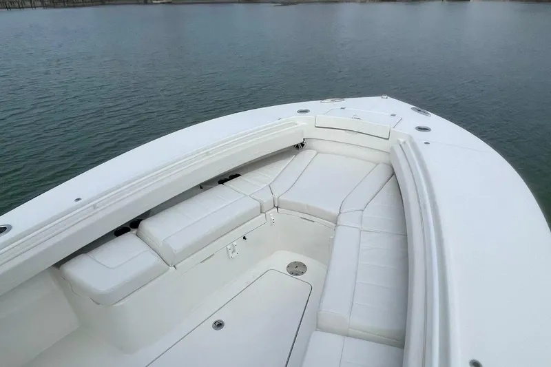 Slide: The Image of 2023 Regulator 28 Forward Seating boat with spacious white seating on calm water. - 4