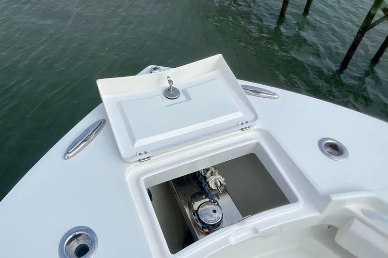 Slide: The Image of 2023 Regulator 28 Forward Seating boat anchor compartment open on calm water. - 7