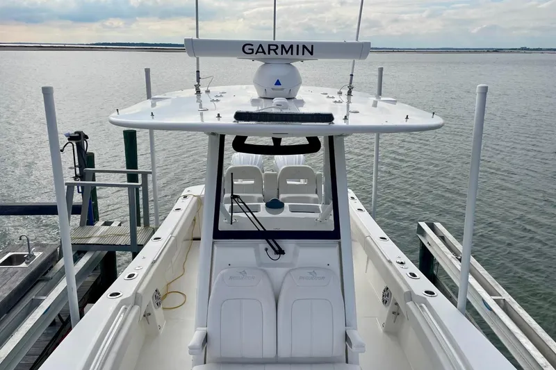 Slide: The Image of 2023 Regulator 28 Forward Seating boat docked, featuring Garmin equipment, on a calm waterway. - 8