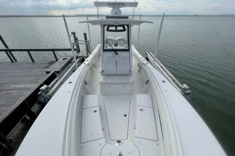 Slide: The Image of 2023 Regulator 28 Forward Seating boat docked, featuring spacious deck and Garmin equipment. - 9
