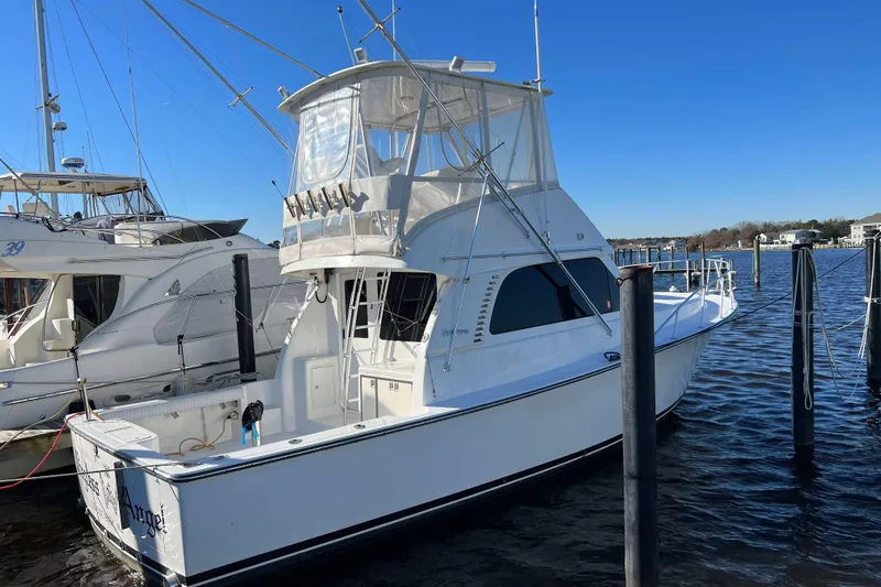 Slide: The Image of 2003 Henriques Yachts 35 Sportfisherman docked in a marina under clear blue skies. - 2