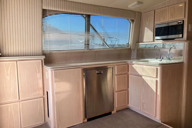 Slide: The Image of 2003 Henriques Yachts 35 Sportfisherman interior kitchen with wood cabinets and stainless steel appliances. - 24