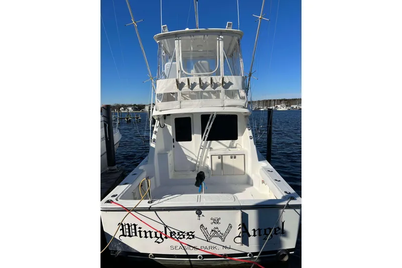 Slide: The Image of 2003 Henriques Yachts 35 Sportfisherman docked, rear view with clear sky background. - 3