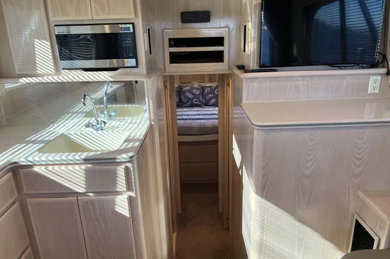 Slide: The Image of 2003 Henriques Yachts 35 Sportfisherman interior with kitchen, sink, microwave, and TV. - 36