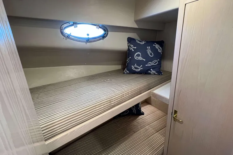 Slide: The Image of 2003 Henriques Yachts 35 Sportfisherman cabin with bunk beds and nautical-themed pillows. - 37