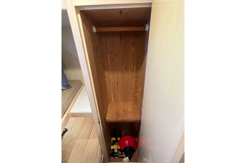 Slide: The Image of Empty wooden closet inside 2003 Henriques Yachts 35 Sportfisherman, with storage items below. - 39