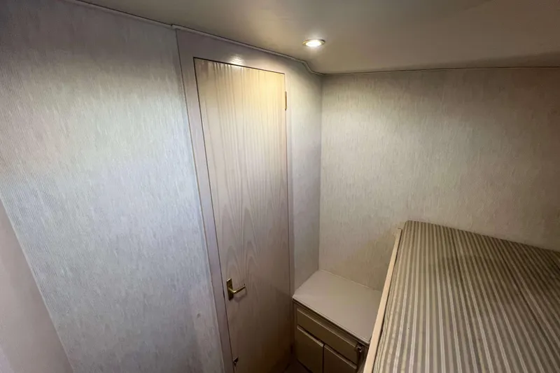 Slide: The Image of Interior cabin of 2003 Henriques Yachts 35 Sportfisherman with wooden door and striped bedding. - 40
