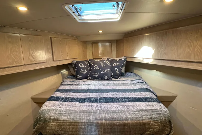 Slide: The Image of Cozy cabin interior of 2003 Henriques Yachts 35 Sportfisherman with striped bedding and nautical pillows. - 49