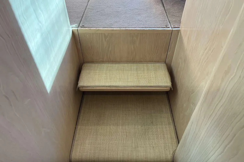 Slide: The Image of Interior stairs of 2003 Henriques Yachts 35 Sportfisherman, featuring wooden paneling and carpeted steps. - 62