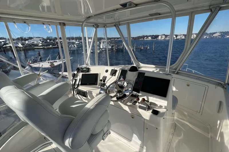 Slide: The Image of 2003 Henriques Yachts 35 Sportfisherman helm with dual seats, overlooking marina and water. - 84