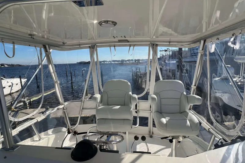 Slide: The Image of 2003 Henriques Yachts 35 Sportfisherman helm with two white captain chairs, overlooking marina. - 90