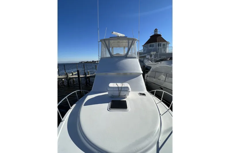 Slide: The Image of 2003 Henriques Yachts 35 Sportfisherman docked, showcasing sleek design and spacious deck. - 96