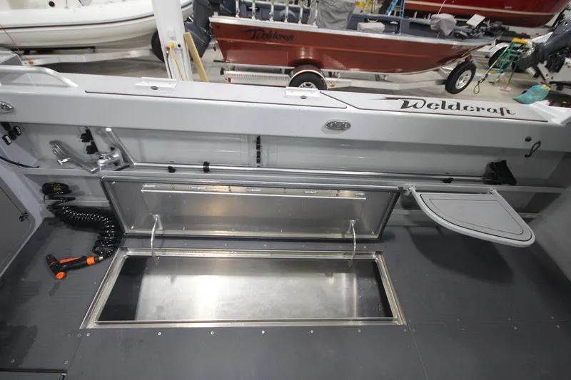 Slide: The Image of 2025 Weldcraft 300 Cuddy King OS boat interior with storage compartment and custom trailer. - 15