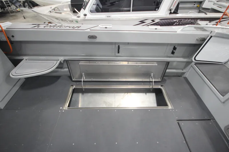 Slide: The Image of 2025 Weldcraft 300 Cuddy King OS boat interior with storage compartments and custom features. - 17