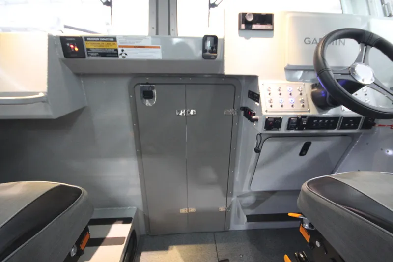 Slide: The Image of Interior of 2025 Weldcraft 300 Cuddy King OS boat with steering wheel and control panel. - 31