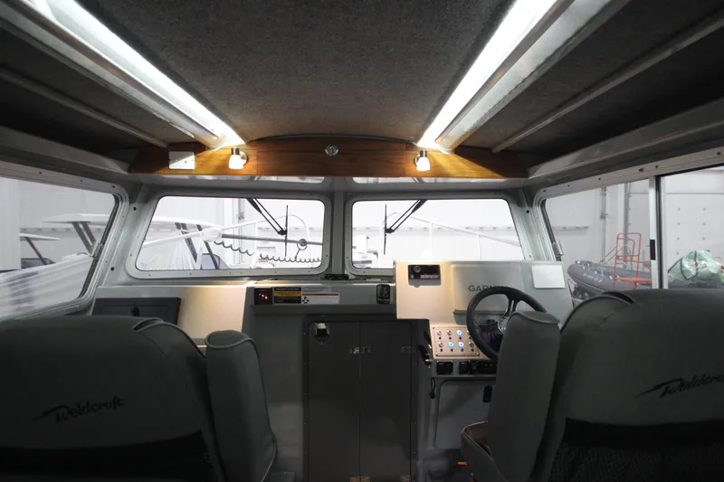 Slide: The Image of Interior of 2025 Weldcraft 300 Cuddy King OS boat with modern controls and seating. - 32