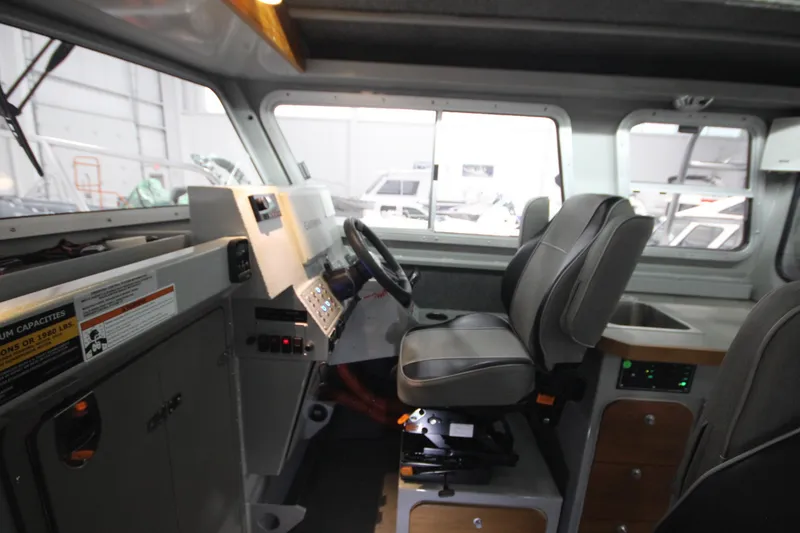 Slide: The Image of 2025 Weldcraft 300 Cuddy King OS interior with steering console and seating. - 35